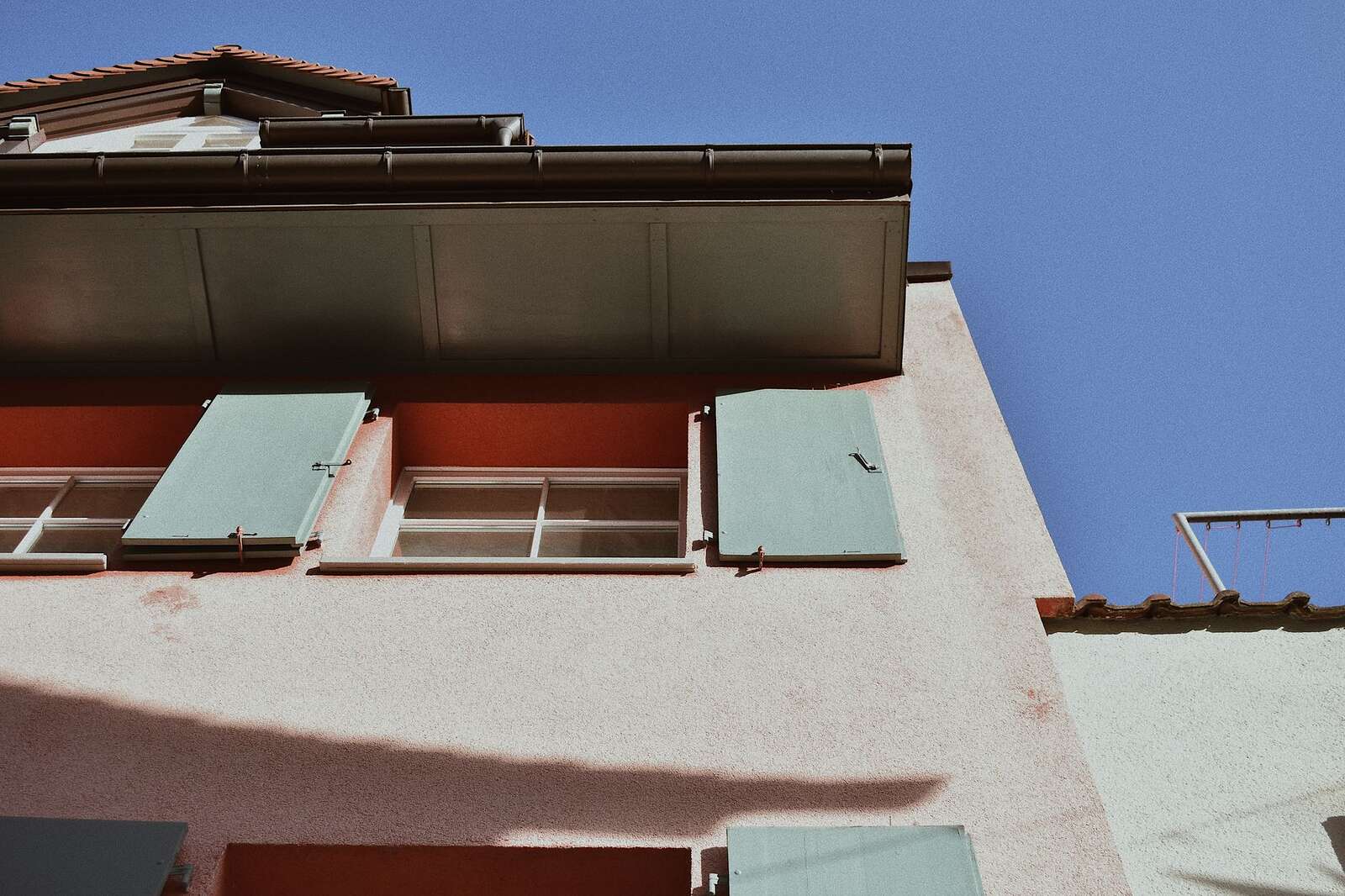 The eave, soffit and fascia line of a house seen from below, where the roofline meets the wall