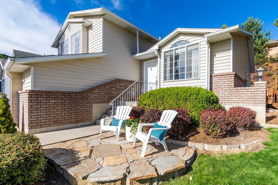 The rear elevation of a brick two-story house with a covered patio