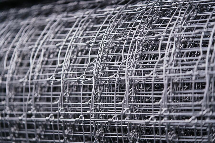 A roll of galvanized quarter-inch hardware cloth on a workbench