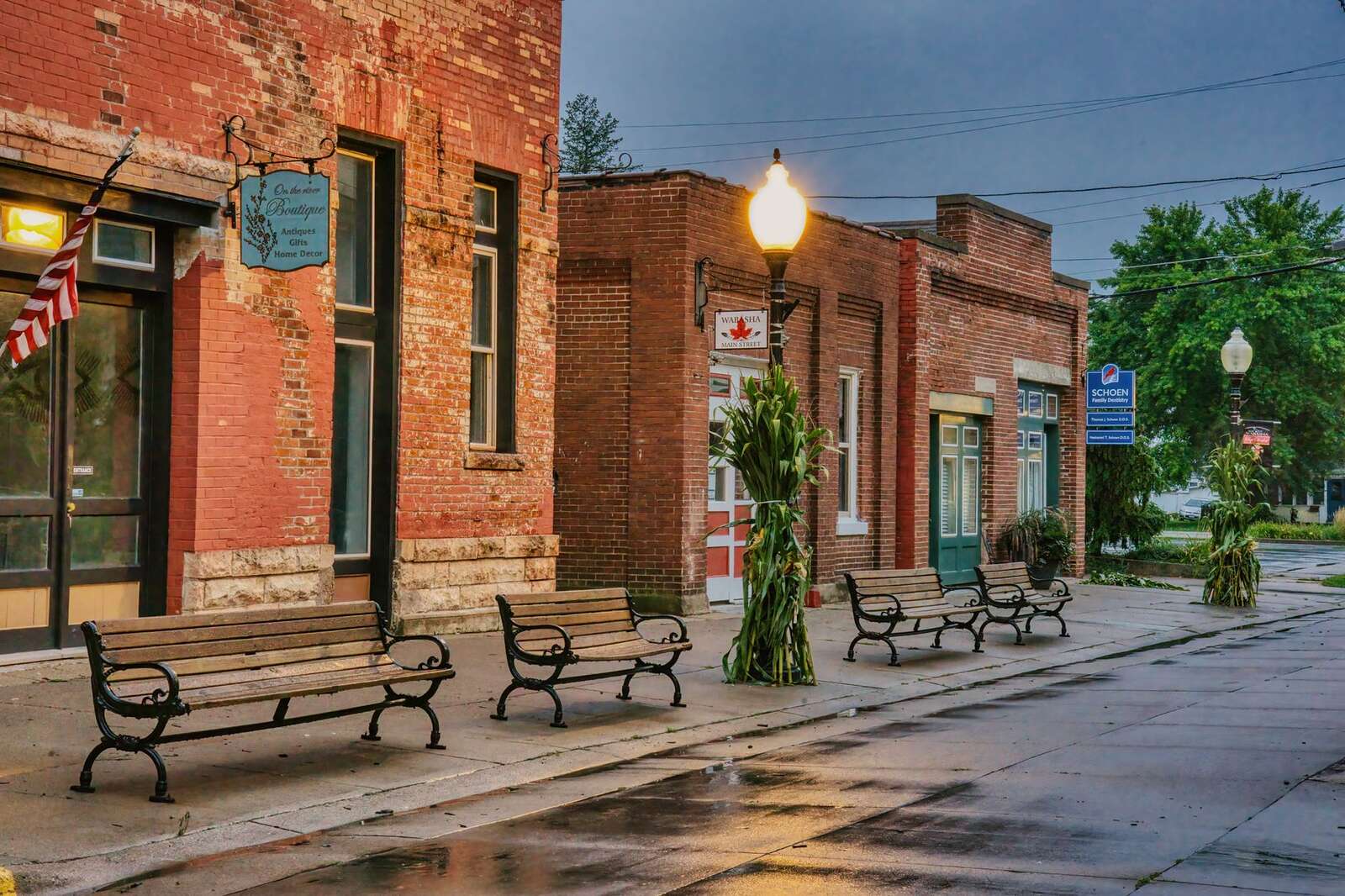 A small-town main street with older brick storefronts and benches