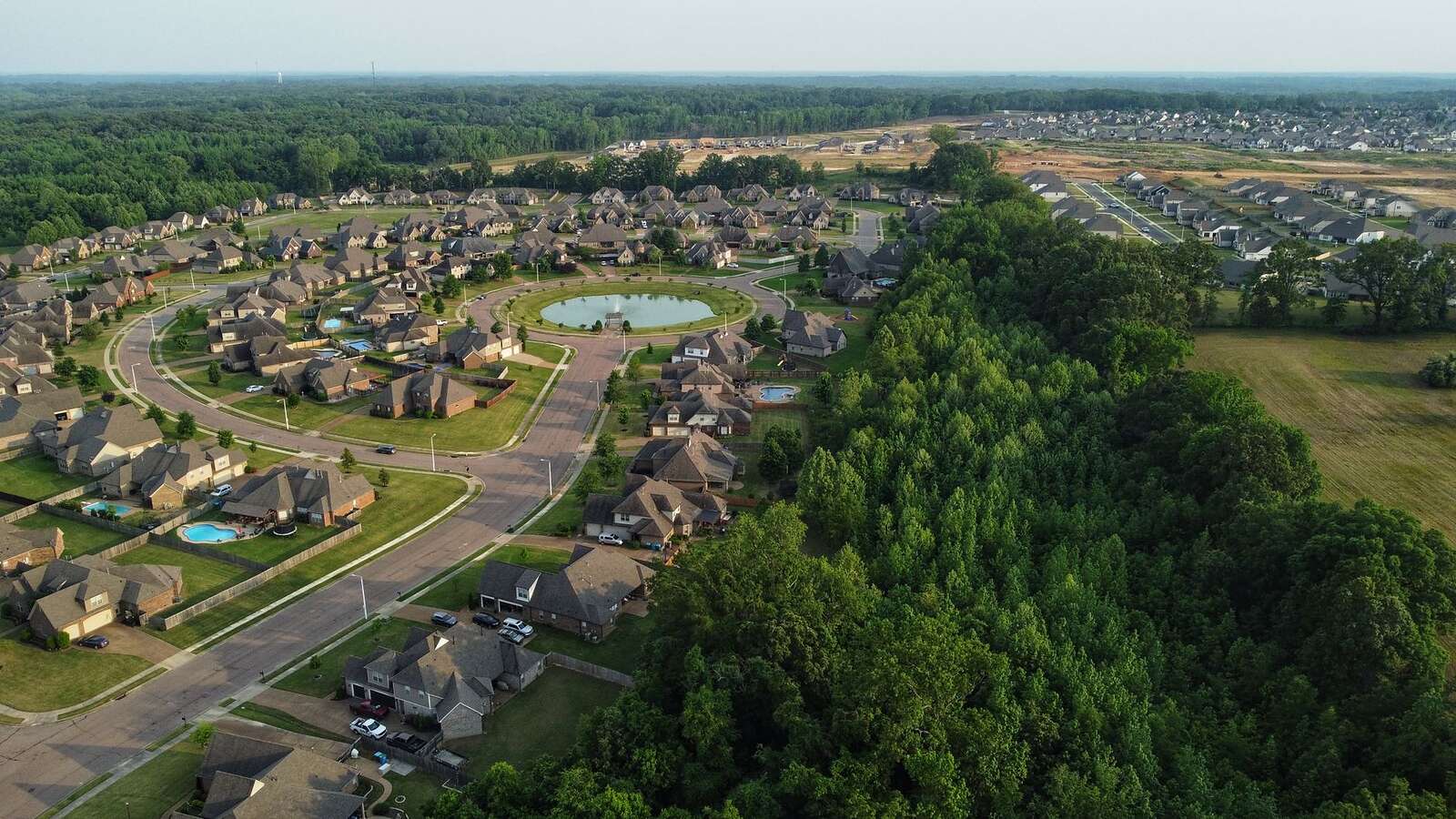 Aerial view of a master-planned subdivision with shingle roofs and cul-de-sacs